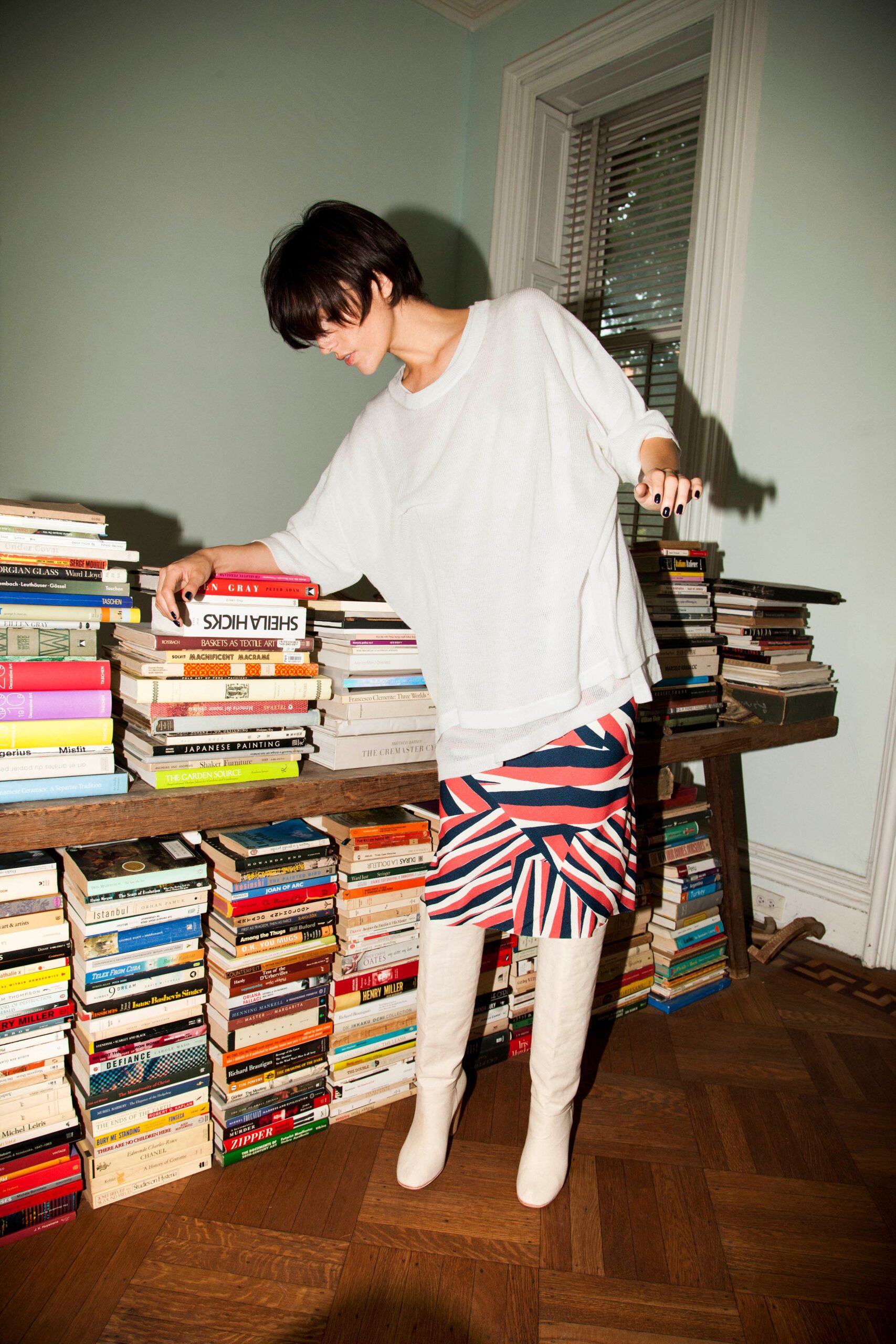 A relaxed white long-sleeve top paired with an asymmetric striped skirt in red and blue.