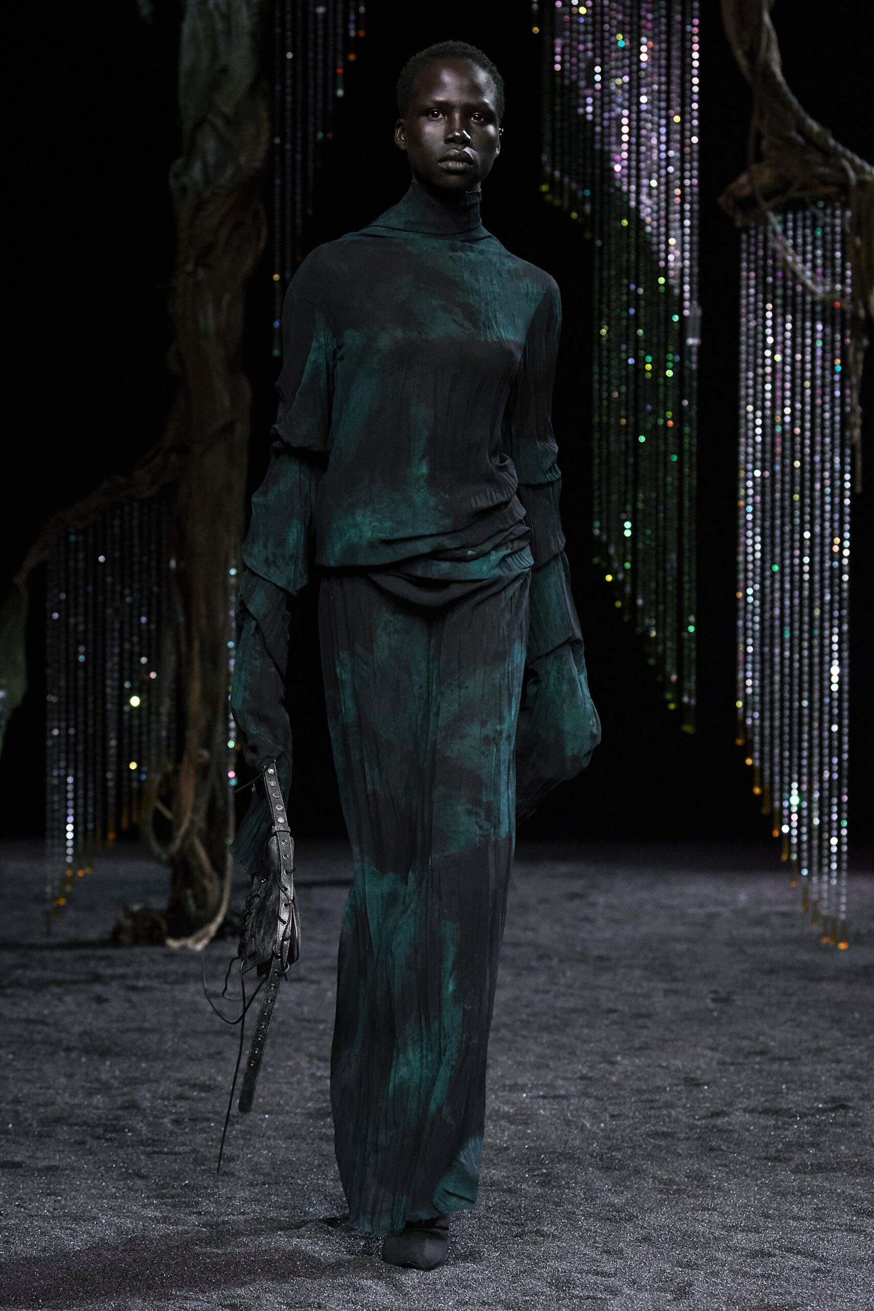A relaxed green and black silk dress with long sleeves and a high-neck design featuring an asymmetric detail.