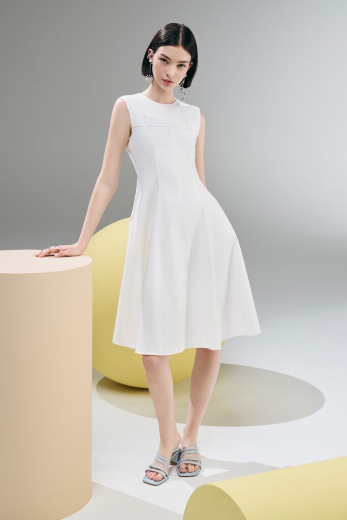 A fitted white sleeveless dress with a high neckline and A-line silhouette.