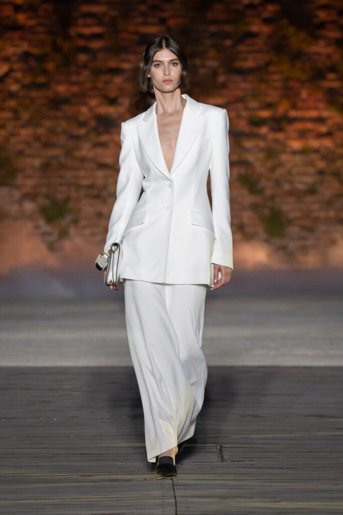 A tailored white silk suit with a V-neckline and straight-leg trousers.