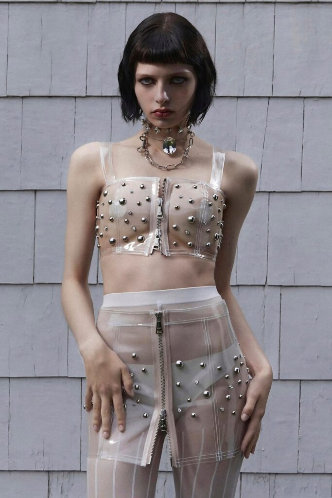 A fitted sleeveless mesh top and skirt with zippered details and embellishments.