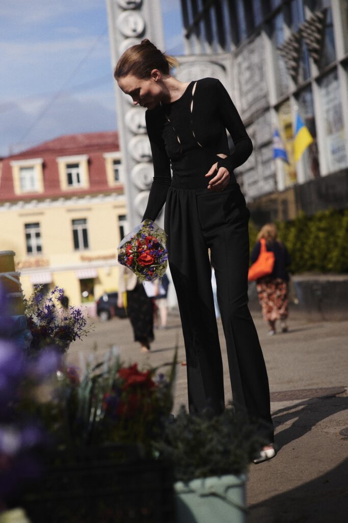 A fitted black jumpsuit with long sleeves and an asymmetric design detail.