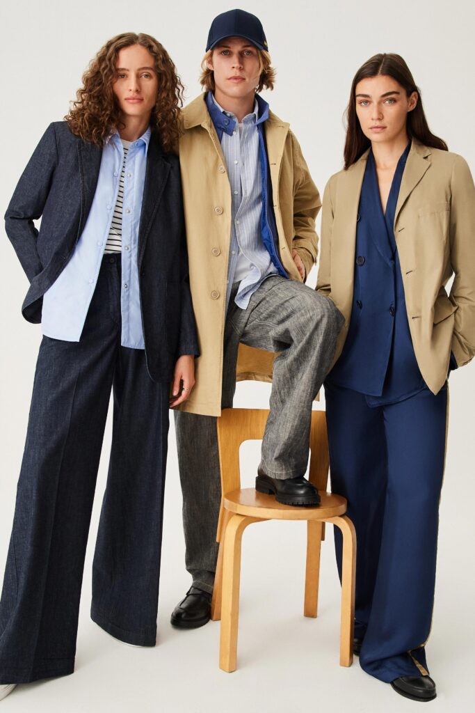 A relaxed-fit beige cotton jacket paired with wide-leg blue pants and a collared shirt.