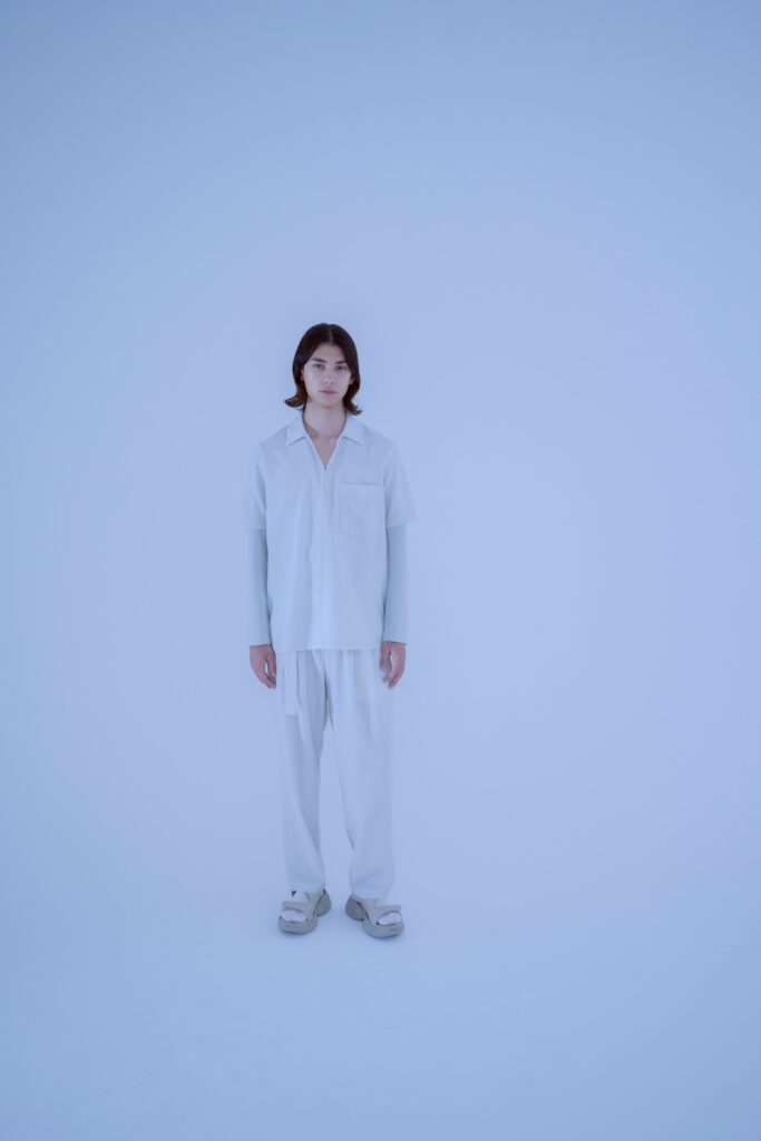 A relaxed white shirt with a collared neckline paired with straight-leg pants.