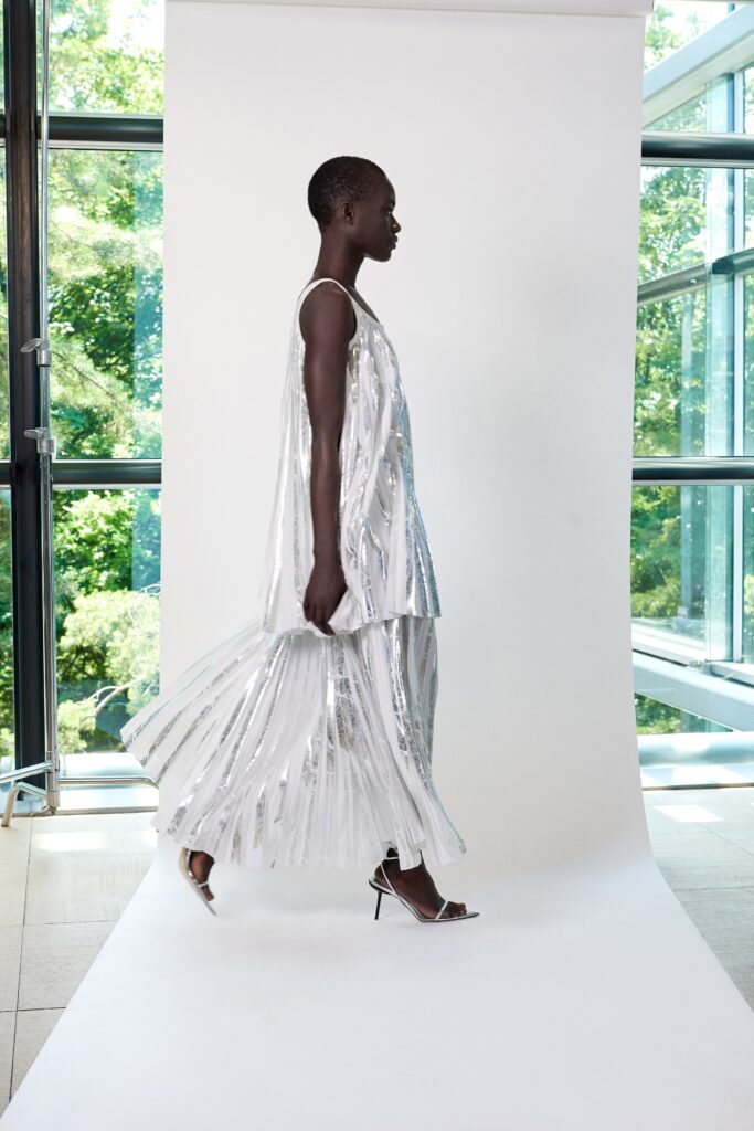A relaxed silver pleated sleeveless dress with a high neckline, perfect for elegant occasions.