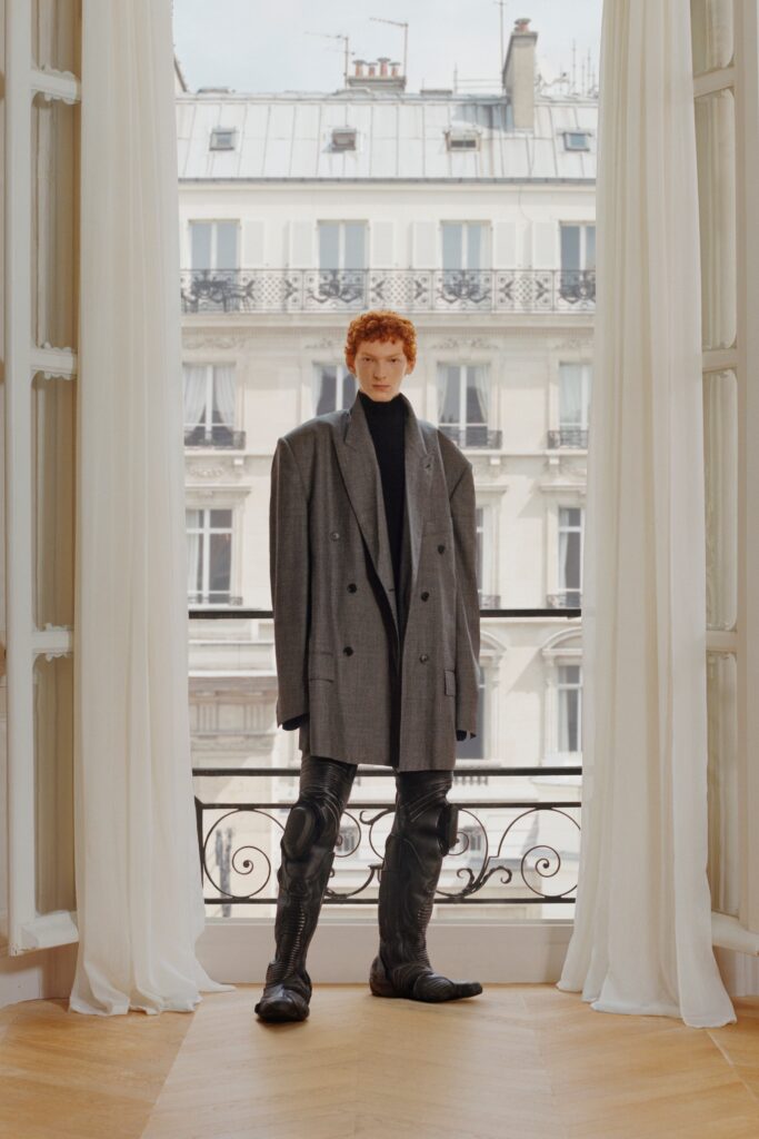 An oversized gray double-breasted blazer paired with straight-leg black pants.