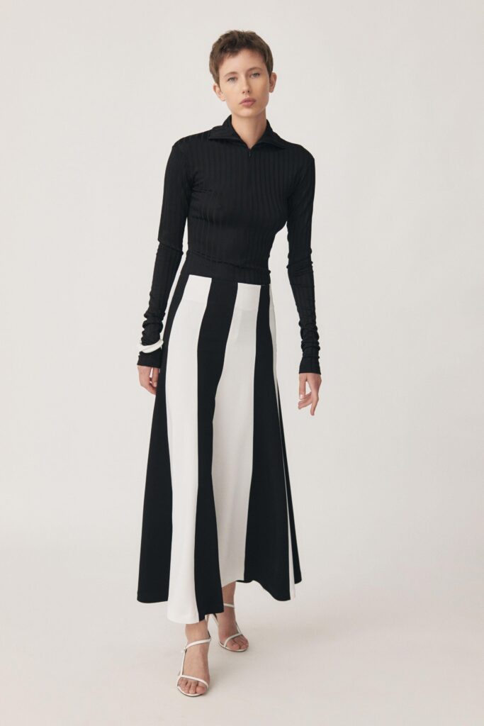 A fitted color-blocked maxi dress featuring long sleeves and a collared neckline.