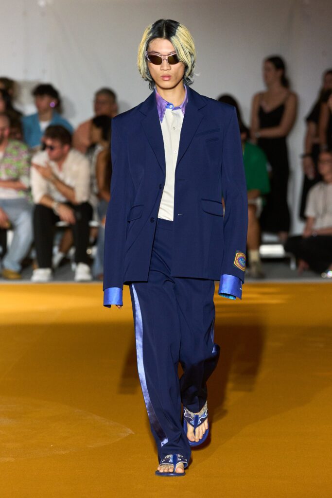 A relaxed blue suit with long sleeves and a collared shirt, featuring buttoned details.