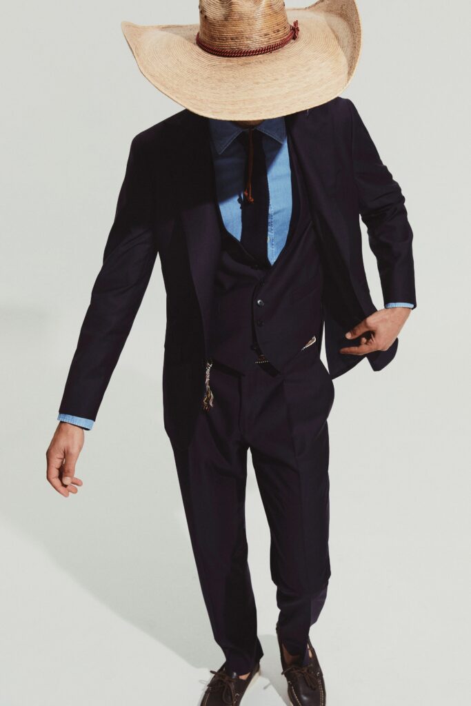 A tailored navy suit with long sleeves and a collared shirt, featuring button details.