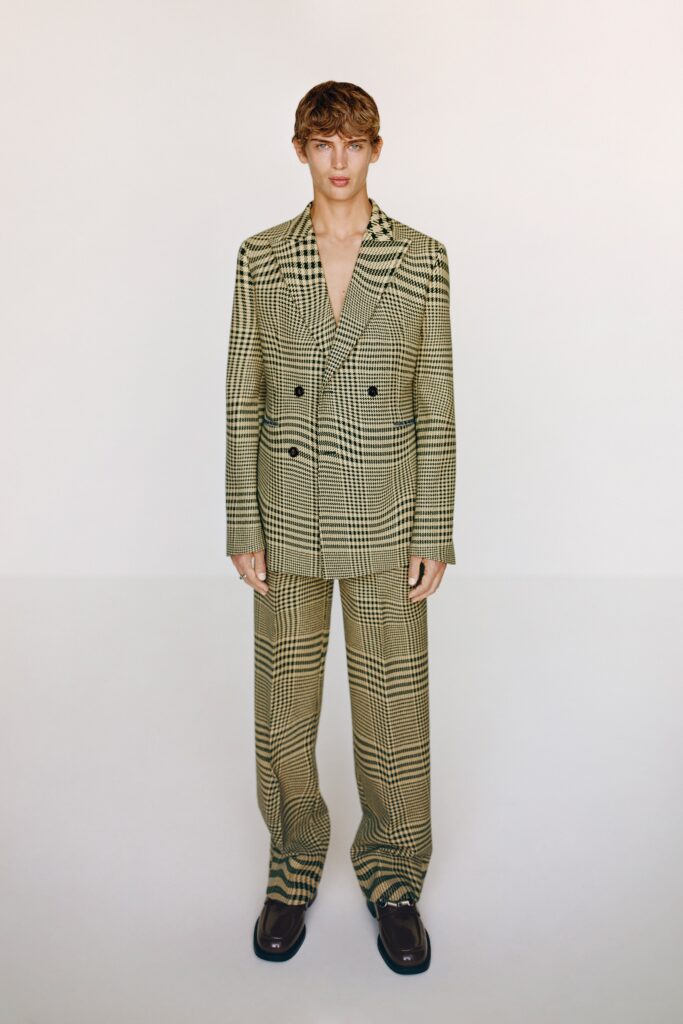 A tailored beige checked suit featuring a long-sleeve collared jacket and matching pants.