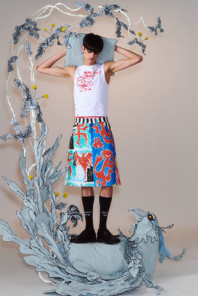 A relaxed white sleeveless top paired with a multicolor printed skirt, showcasing vibrant artistic designs.