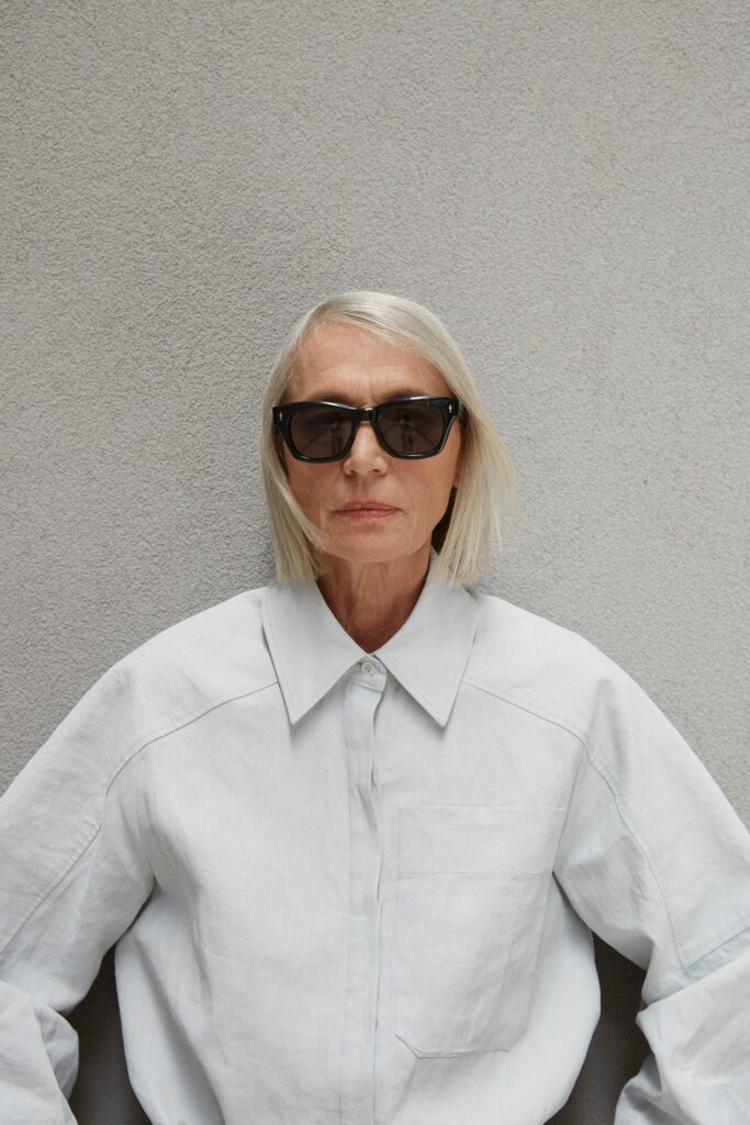 A relaxed white cotton shirt with long sleeves and a collared neckline, featuring button details.