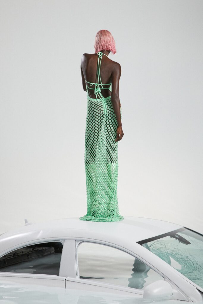 A fitted green mesh dress with a halter neckline and tiered design.