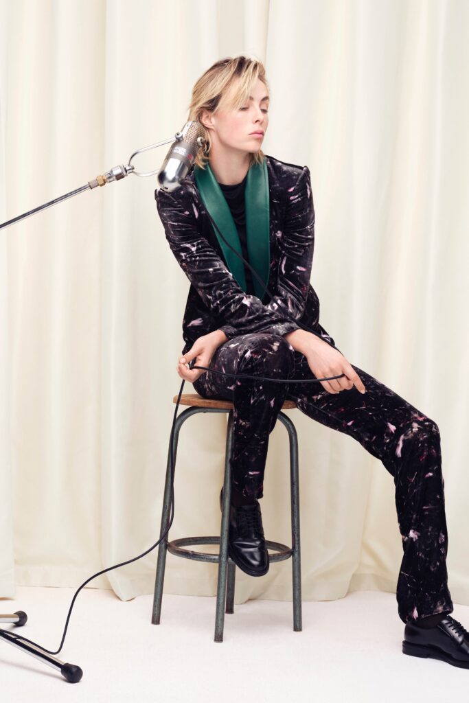 A fitted black velvet suit with a collared long-sleeve jacket and printed design.