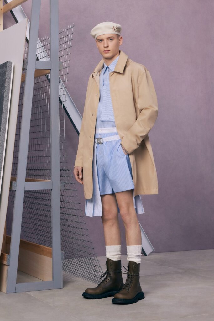 A beige buttoned coat paired with blue striped shorts, creating a stylish casual look.