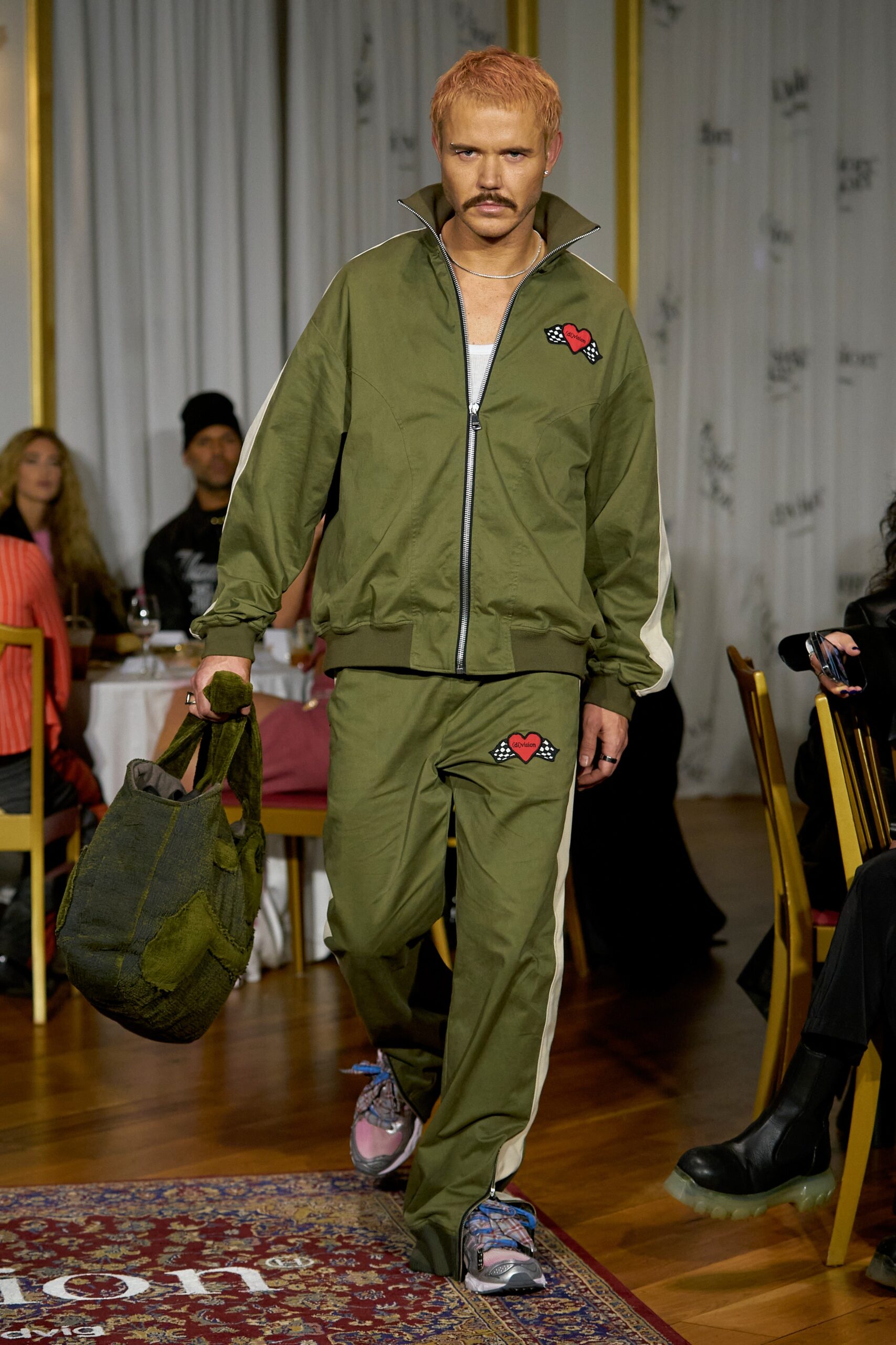 A relaxed green jacket with a collar and matching pants, featuring a zippered detail.