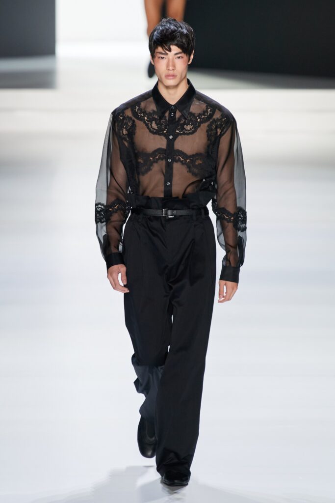 A relaxed black sheer long-sleeve shirt with embroidery paired with black pants.