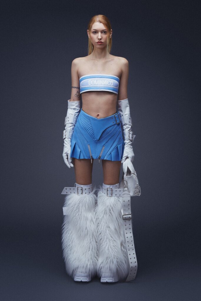 A fitted blue sleeveless top paired with a pleated skirt featuring fringed details.