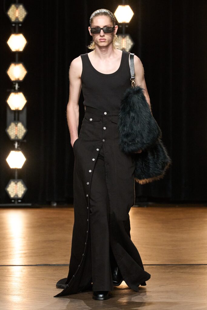A fitted black sleeveless dress with a V-neckline and buttoned details.