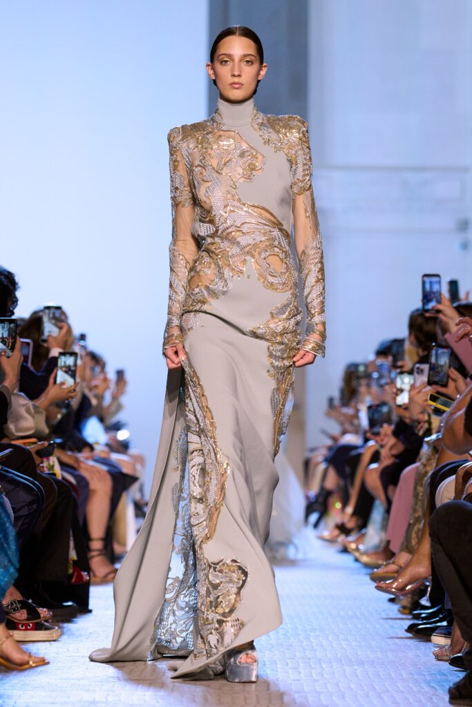 A fitted gray silk gown with long sleeves, high neckline, and intricate embroidery.
