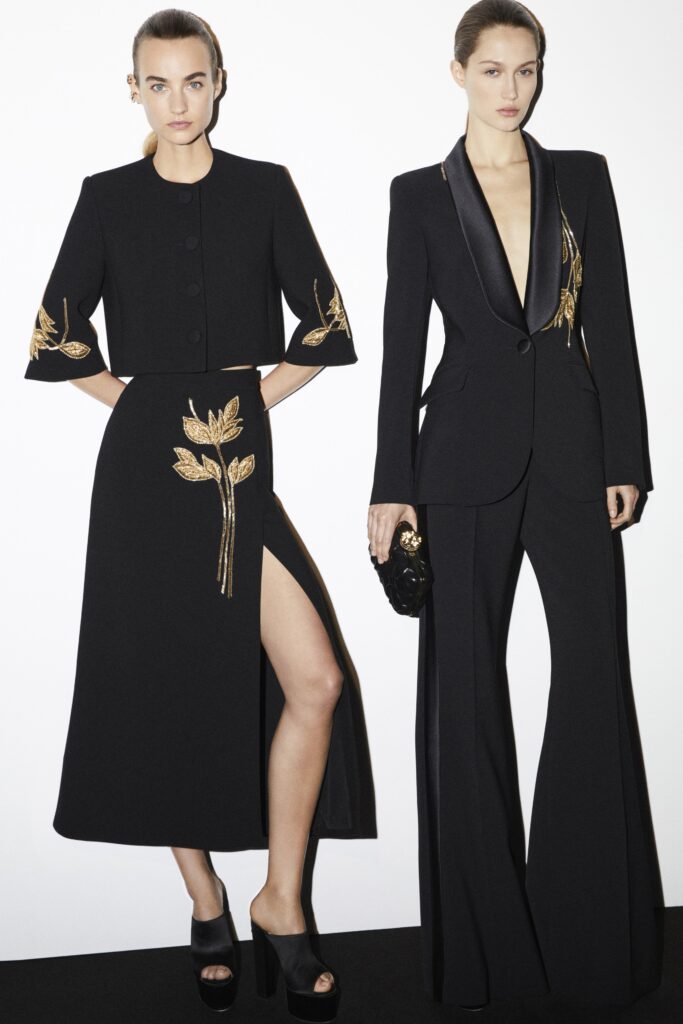 A fitted black wool dress with a slit and an embroidered jacket, perfect for formal occasions.