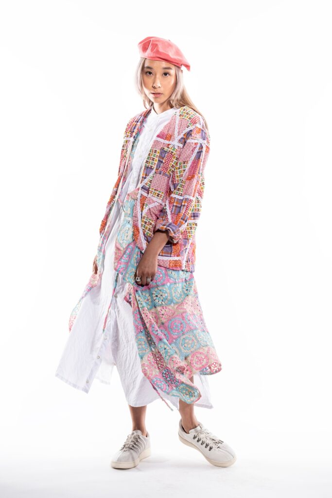 A relaxed multicolor dress with long sleeves and a collared design, featuring layered details.