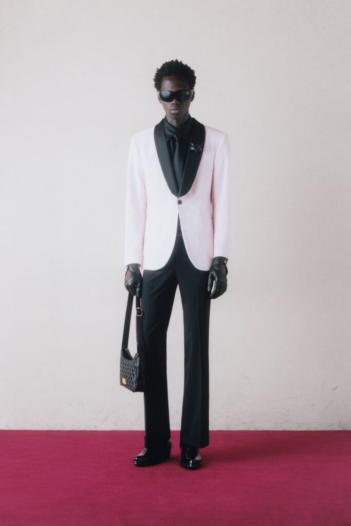 A tailored pink and black suit with a collared long-sleeve shirt and buttoned details.
