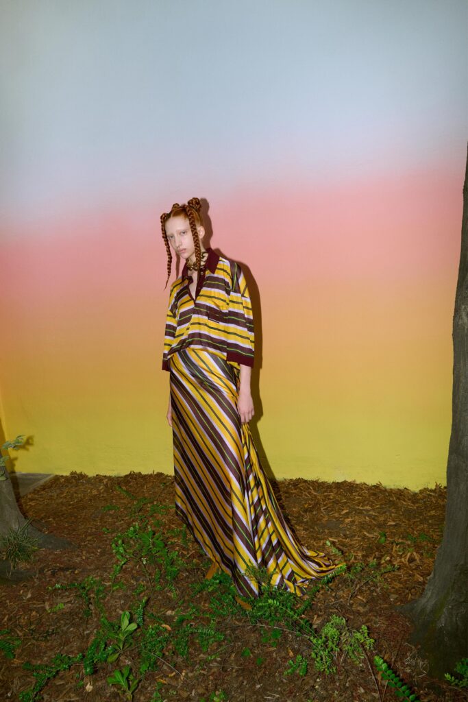 A relaxed yellow and purple striped dress with a V-neckline and short sleeves.