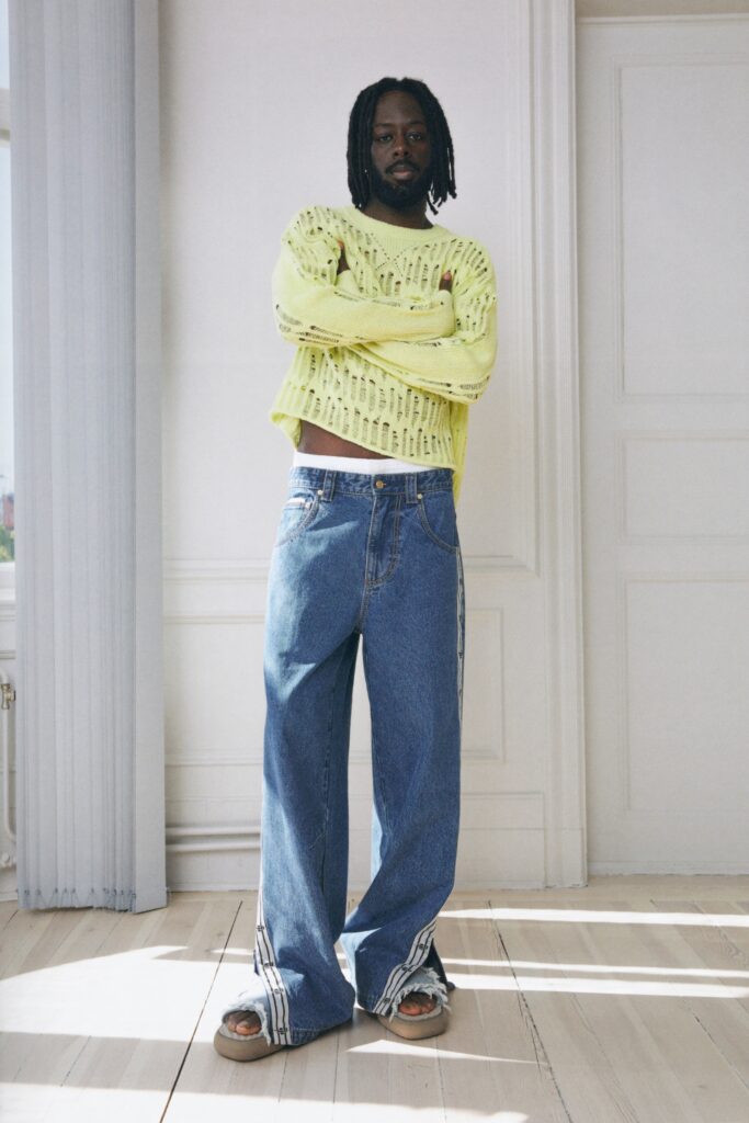 A relaxed yellow long-sleeve sweater paired with blue jeans featuring a layered design.