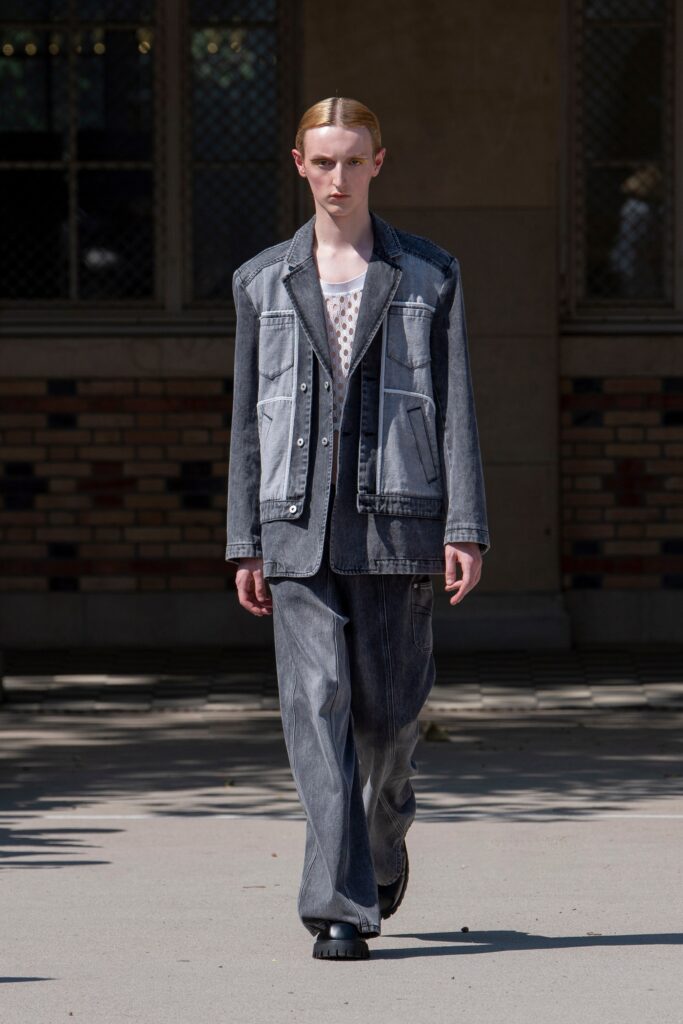 A relaxed blue denim jacket with long sleeves and collared design, paired with wide-leg denim pants.