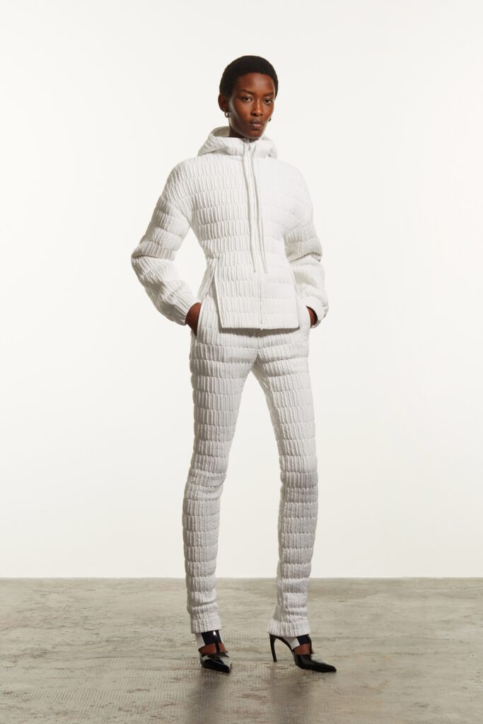 A fitted white hoodie with long sleeves paired with matching fitted pants, featuring a textured design.