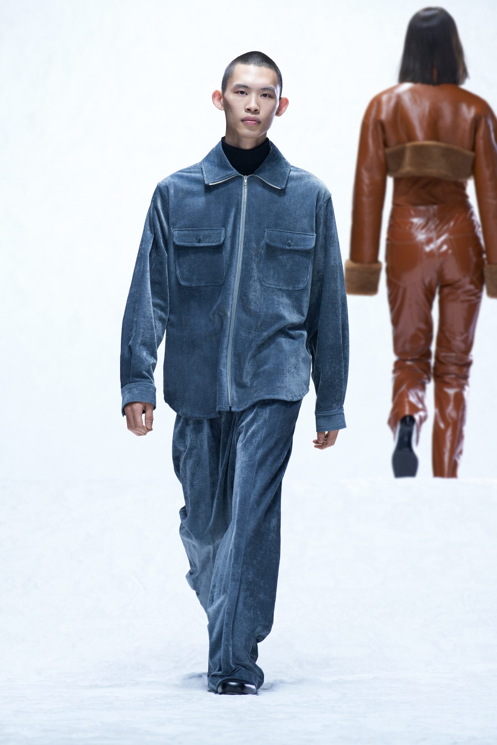 A relaxed blue velvet jacket with long sleeves and collared design paired with straight-leg pants.