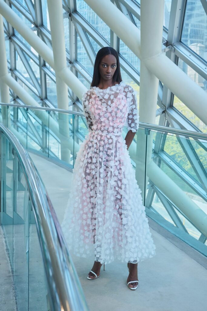 A fitted white and pink layered dress with long sleeves and a V-neckline.
