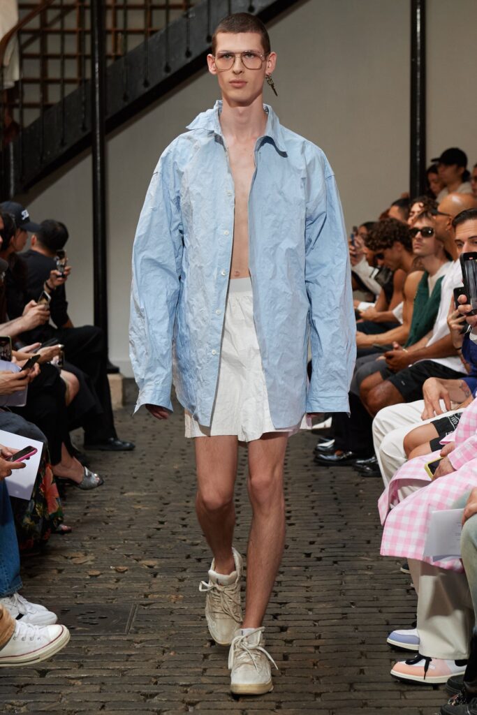 A relaxed blue cotton long-sleeve shirt paired with white shorts, featuring a collared design.