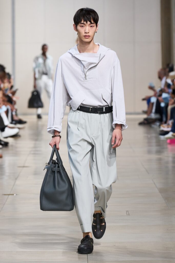 A relaxed white cotton long-sleeve shirt with a collared design paired with gray pants.