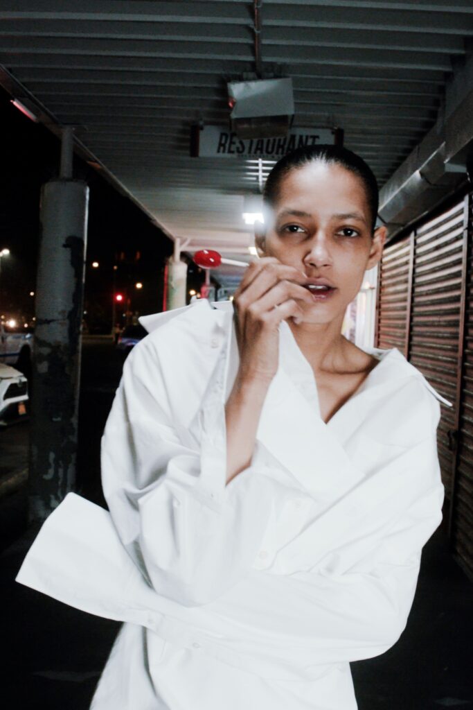 An oversized white cotton shirt with long sleeves and a collared neckline, featuring button details.