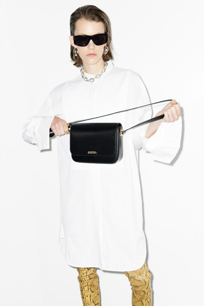 An oversized white cotton shirt-dress with long sleeves and a collared neckline.