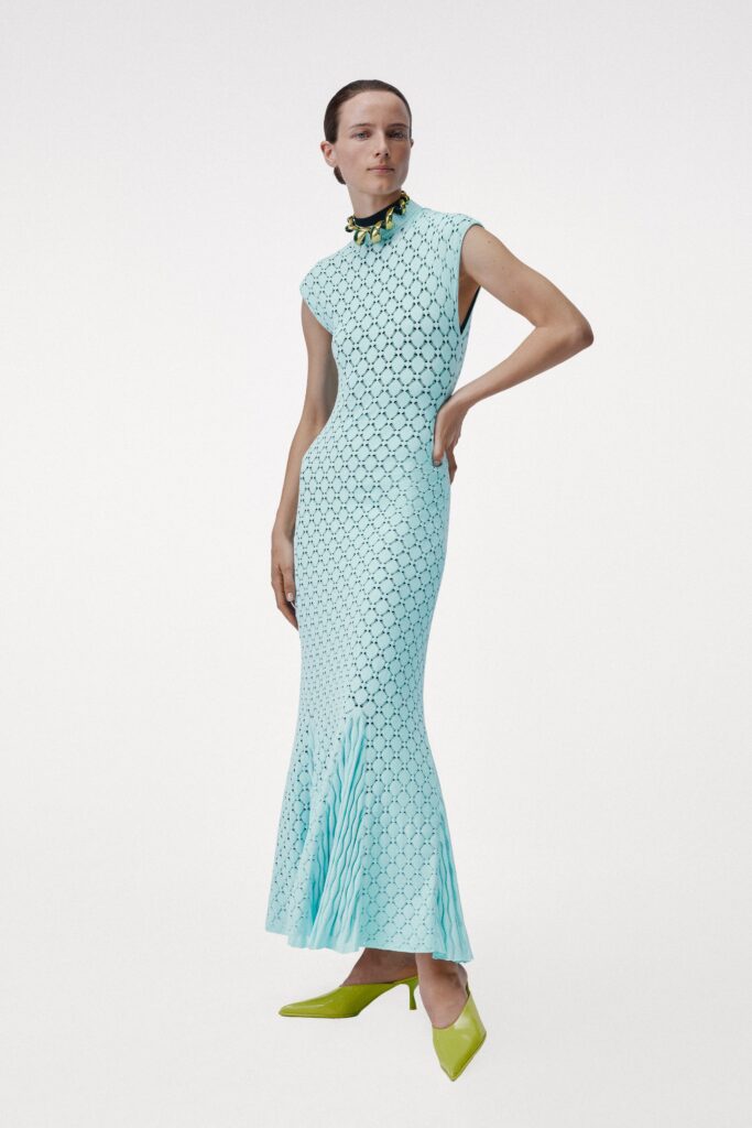 A fitted blue sleeveless dress with a high neckline and flared silhouette.