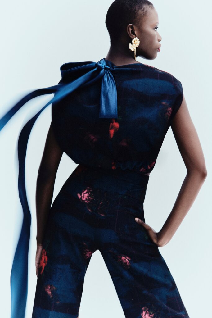 A fitted blue and black silk jumpsuit with a sleeveless design and asymmetric details.