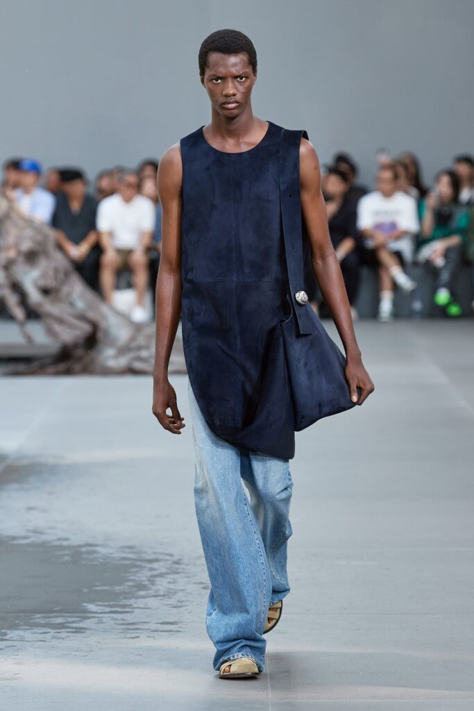 A relaxed blue sleeveless top paired with wide-leg denim pants for a modern look.
