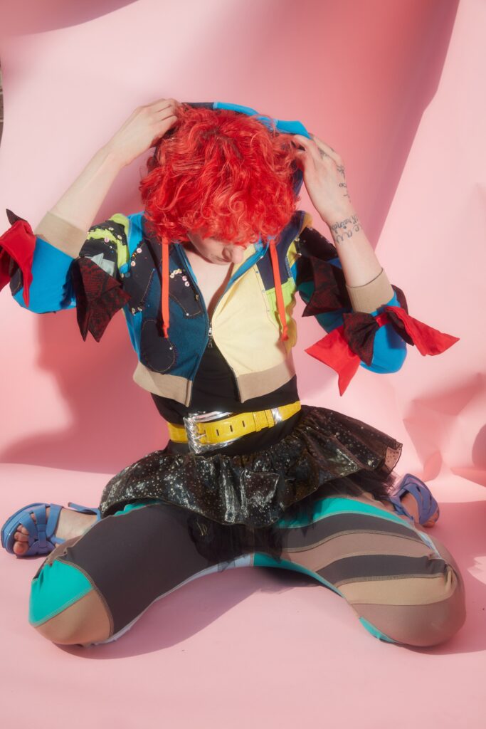 A fitted multicolor hoodie with long sleeves and a layered skirt, showcasing a playful style.