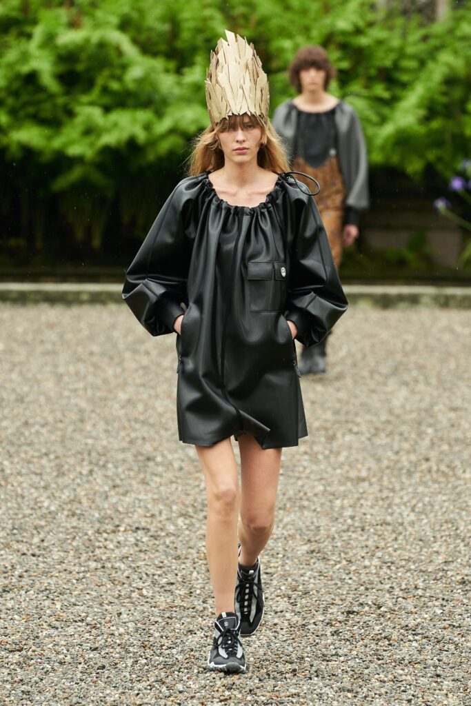 A relaxed black leather dress with long sleeves and an asymmetric design.