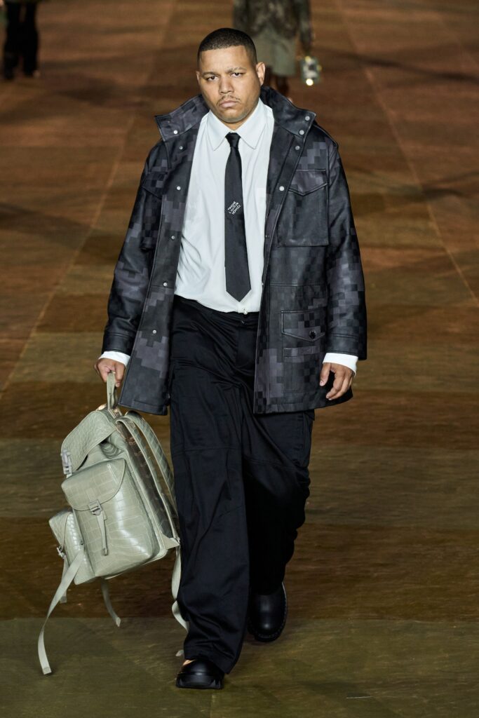A relaxed black coat with long sleeves and a collared design, paired with matching pants.