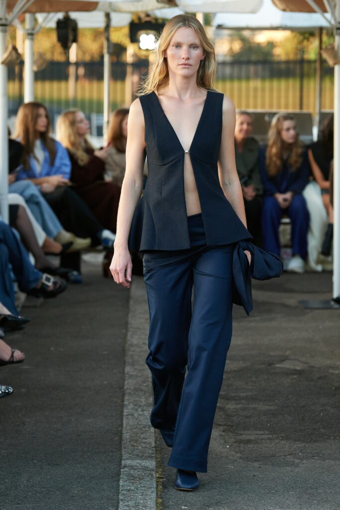 A fitted navy sleeveless top with a V-neckline paired with matching pants featuring an asymmetric design.