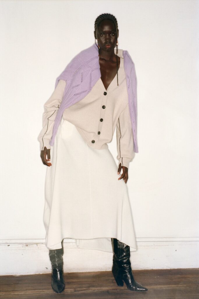 A relaxed beige long-sleeve top with a collared design paired with a tiered white skirt.