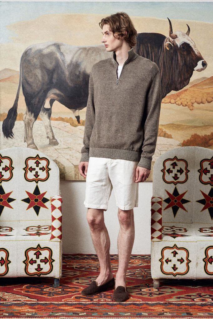A relaxed brown wool sweater with a zippered collar paired with white cotton shorts.
