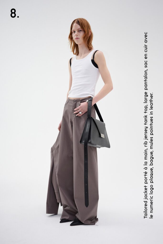 A relaxed white sleeveless top paired with high-waisted brown wide-leg pants.
