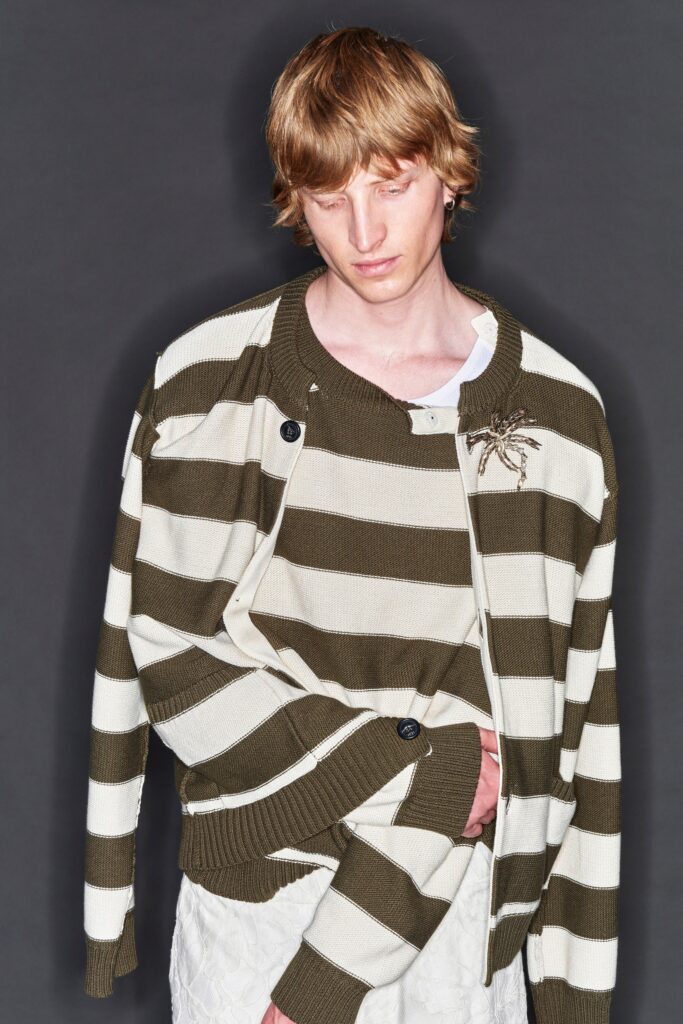 A relaxed-fit beige and green striped sweater with long sleeves and a collared neckline.