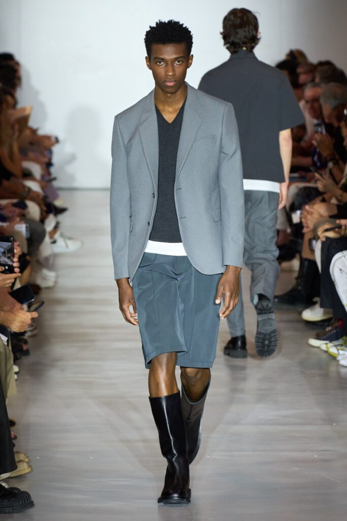 A fitted gray blazer paired with black shorts, featuring a short-sleeve design and asymmetric details.