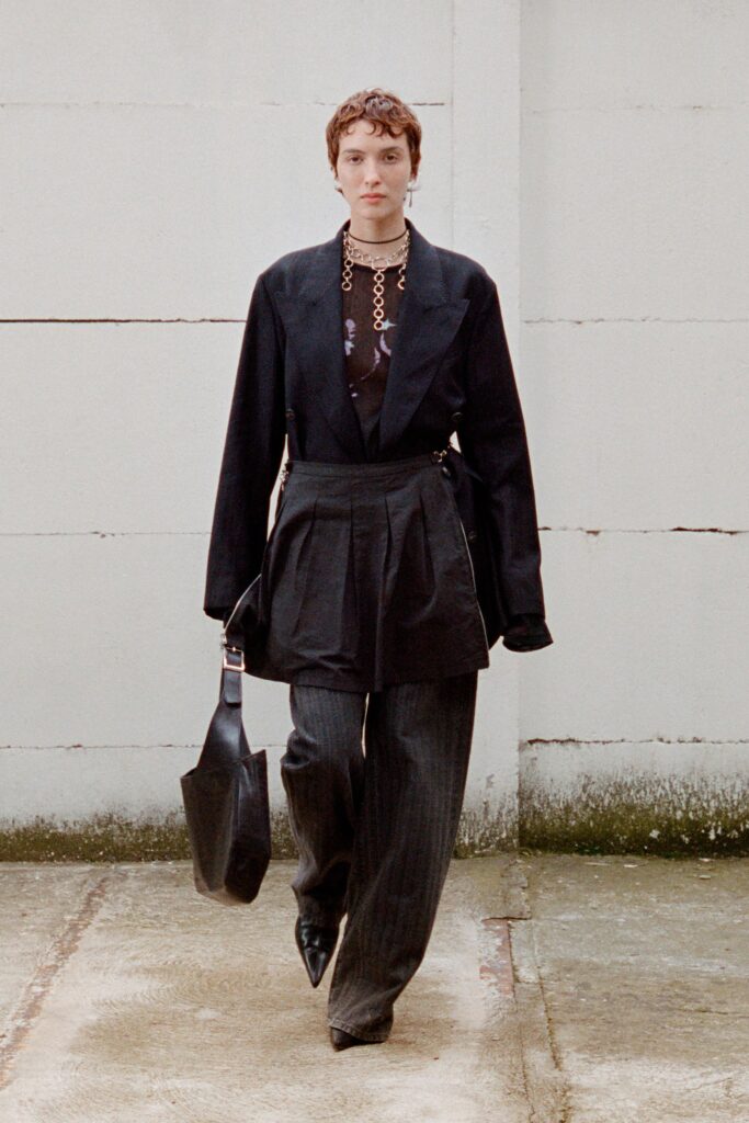A relaxed black jacket with long sleeves paired with pleated wide-leg pants.
